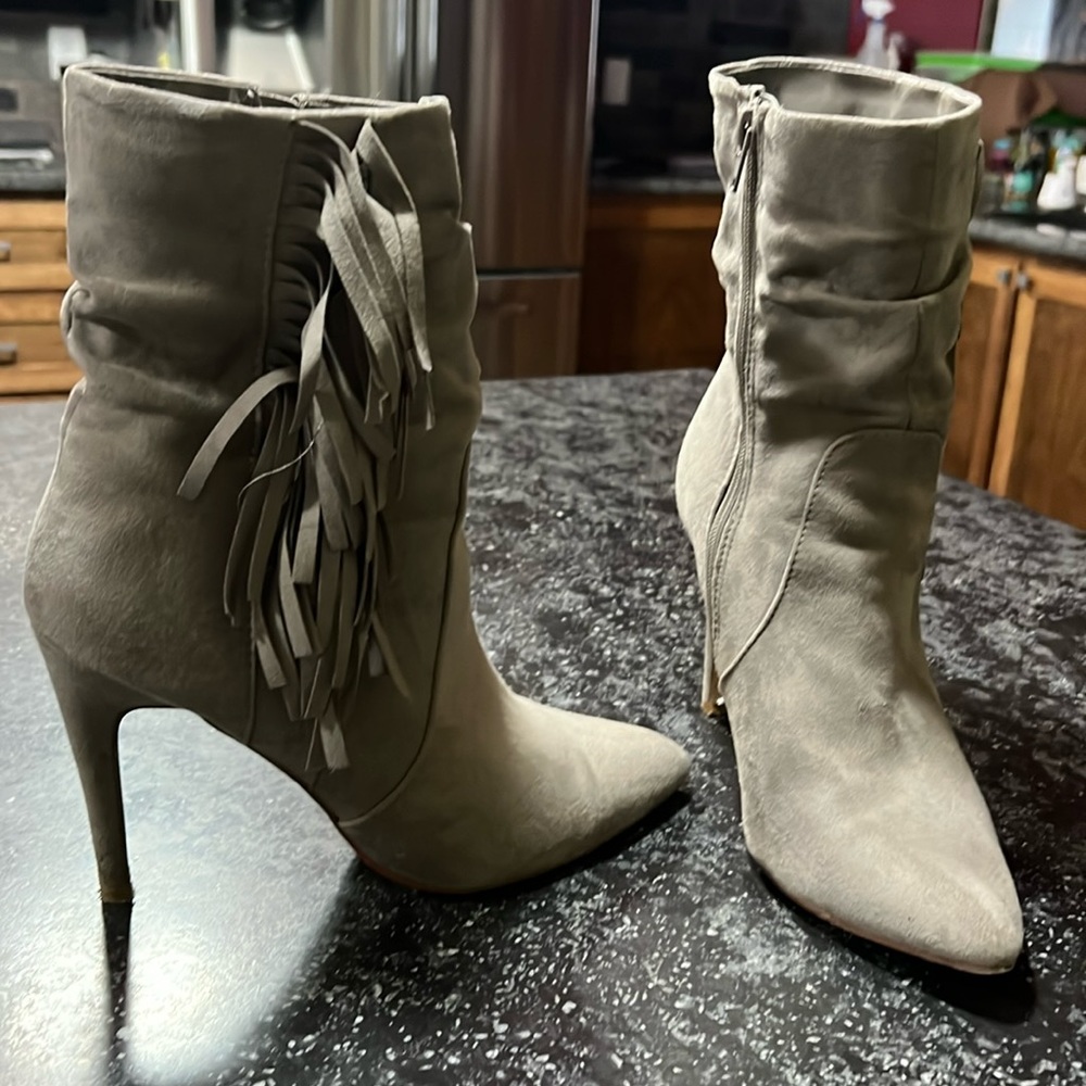 Inside seam zip up low boots with outside fringe.